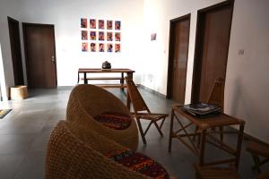 ein Wohnzimmer mit einem Sofa und einem Tisch in der Unterkunft Les Amazones Rouges Chambre Jaune in Ouidah