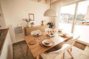 - une salle à manger avec une table et des chaises en bois dans l'établissement Traumhafte Seelodge mit Sauna, Kamin und Whirlpool, à Nordhorn