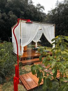 a gazebo with a curtain on a wooden deck at Ônibus Oriental com Ofurô - Domingos Martins ES in Domingos Martins +29 photos