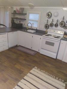 a kitchen with white cabinets and a sink and a stove at Mi-o My Getaway in Mio