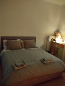 a bedroom with a bed with two towels on it at Serenity's Sunset Terrace in Shkodër