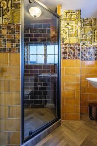 a glass shower in a bathroom with a sink at The Famous Harry Potter House in Saffron Walden
