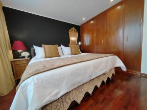 a bedroom with a large bed with a wooden wall at ANA FRANK Boutique Hotel in Lima