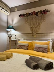 een slaapkamer met een groot bed en een gele deken bij 22 La Maisonette in Karpenisi
