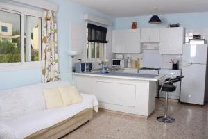 a small kitchen with white cabinets and a white refrigerator at Happy Holiday in Coral Bay