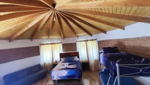 Habitación con 2 camas y techo de madera. en cabañas katchi en San Pedro de Atacama