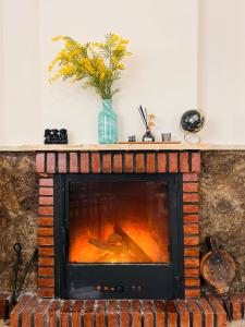a brick fireplace with orange flames in a living room at Casa Rural Senda de los Lobos in Uclés