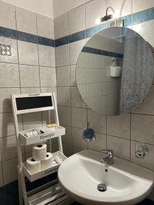 ein Bad mit einem Waschbecken und einem Spiegel in der Unterkunft 22 La Maisonette in Karpenisi