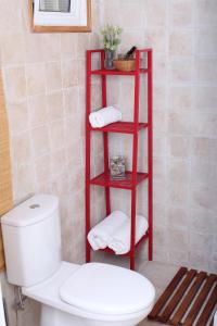 um toalheiro vermelho ao lado de um WC numa casa de banho em Happy Holiday em Coral Bay