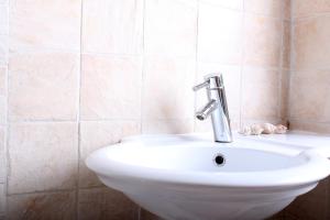 a bathroom with a sink and a faucet at Happy Holiday in Coral Bay