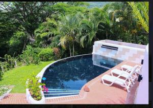 una piscina con 2 tumbonas junto a ella en Apartment with loft in Altos del Maria en Sorá