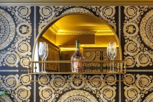 un espejo con una botella y gafas en un estante en Versace 2 Bed Manor House With Hot Tub, en Saffron Walden