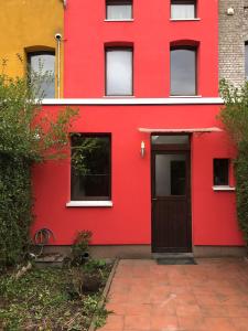 um edifício vermelho com uma porta em frente em Cozy & Comfy House in Forest! em Bruxelas