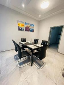 a dining room with a black table and chairs at Serenity Haven:Your Ideal Escape in Lomé