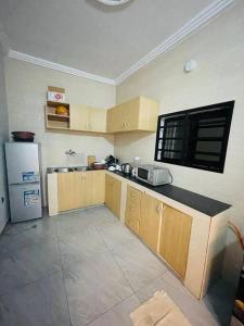 a kitchen with wooden cabinets and a refrigerator at Serenity Haven:Your Ideal Escape in Lomé