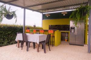 eine Terrasse mit einem Tisch und Stühlen sowie einer gelben Wand in der Unterkunft Hotel Campestre Morichal in Tauramena