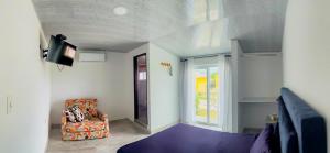 a living room with a chair and a tv at Hotel Campestre Morichal in Tauramena
