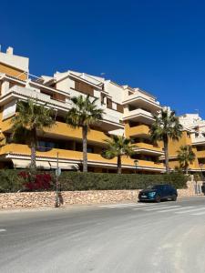 a car parked in front of a building with palm trees at Apartamento Punta Prima in Torrevieja