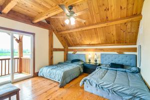 two beds in a room with a wooden ceiling at Angleton Vacation Rental with On-Site Lake Access! in Angleton