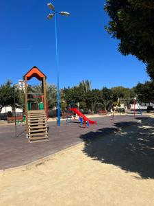 a park with a playground with swings and a light at Apartamento Punta Prima in Torrevieja