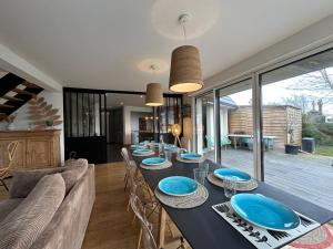 a dining room with a long table with blue plates at Villa Marius proche de la plage in Ambleteuse +10 photos