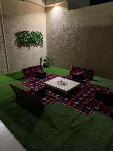 Zimmer mit Stühlen und einem Tisch auf einem Teppich in der Unterkunft الجود مخيم شقة استراحة بيت in Chamis Muschait