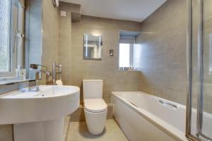 La salle de bains est pourvue d'un lavabo, de toilettes et d'une baignoire. dans l'établissement Lionsgate View - luxury apartment opposite Alnwick Castle, à Alnwick