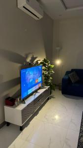 uma sala de estar com uma televisão de ecrã plano sobre uma mesa em الجود مخيم شقة استراحة بيت em Khamis Mushayt
