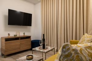 a living room with a television and a bottle of wine at Floret Apartment in Cavtat