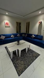 a living room with a blue couch and a table at الجود مخيم شقة استراحة بيت in Khamis Mushayt