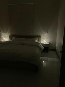 a bedroom with a bed with two lamps on it at الجود مخيم شقة استراحة بيت in Khamis Mushayt