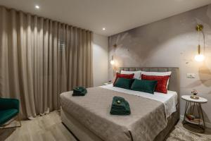 a bedroom with a large bed with green and red pillows at Floret Apartment in Cavtat