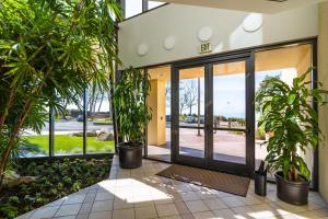 un hall avec des plantes en pot devant un bâtiment dans l'établissement Villa Graziadio Executive Center at Pepperdine University, à Malibu