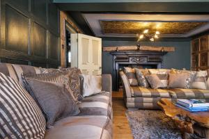 a living room with two couches and a fireplace at Luxury 3 Bed Manor House Hot Tub & Cinema in Saffron Walden