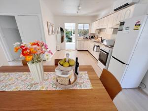 Norah50 meters to the beach Hargraves Beach Cottage的厨房配有白色家电和水果瓶