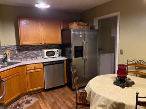 a kitchen with a table and a stainless steel refrigerator at Happy Place in Conley
