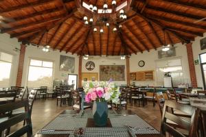 un comedor con un jarrón de flores sobre una mesa en Hotel Real de San Jose en Tequisquiapan