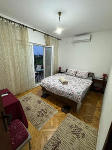 a bedroom with a bed and a room with rugs at Airport home Radinovic in Podgorica