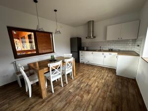 a kitchen with a wooden table and white cabinets at Riverside Woodhouses in Praid