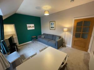 a living room with a couch and a table at Carronvale. 3 Bedroom Oban Apartment. in Oban