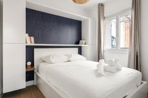 - une chambre avec un lit blanc et une tête de lit noire dans l'établissement Un T3 sur le port de La Ciotat, à La Ciotat