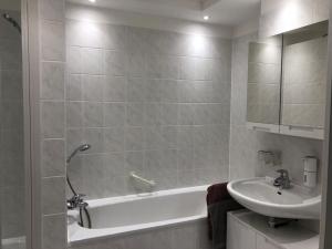 a bathroom with a bath tub and a sink at New Apartment mit Terrasse in Hannover