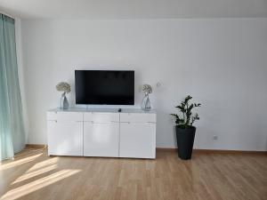 un armario blanco con un televisor encima. en New Apartment mit Terrasse, en Hannover