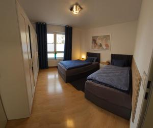 um pequeno quarto com 2 camas e uma janela em New Apartment mit Terrasse em Hanôver