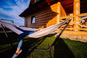 a person laying in a hammock in front of a cabin at Sielanka u Stanka in Szaflary