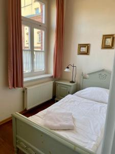 博爾納的住宿－Hotel zur Schlossmühle，卧室配有白色的床和窗户。