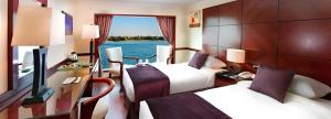 a hotel room with two beds and a window at NILE CRUISE ULTRA DELUXE in Aswan