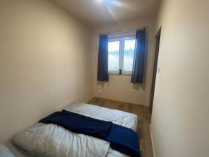 a small bedroom with a bed and a window at Domek całoroczny nad rzeką Wkra in Pomiechówek