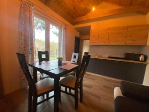 een keuken en eetkamer met een tafel en stoelen bij Domek całoroczny nad rzeką Wkra in Pomiechówek