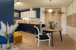a kitchen with a table and chairs in a room at Loftowe Pokoje in Góra Puławska